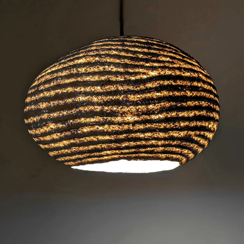 Owalna lampa wisząca z papier mache. Abażur uformowany z cieńszych i grubszych warstw. Naturalne komponenty, Vegan. Model 21.